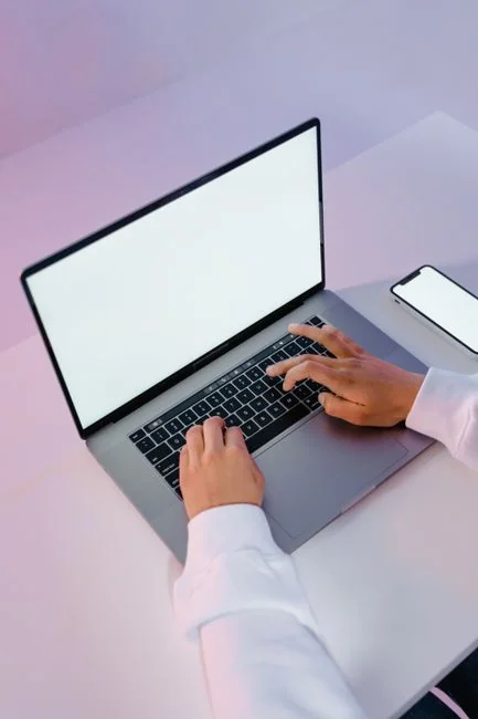 Une configuration de bureau élégante mettant en avant des appareils Apple : iMac, MacBook et iPad.